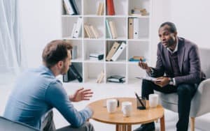 behavioral health male psychologist asking male patient questions