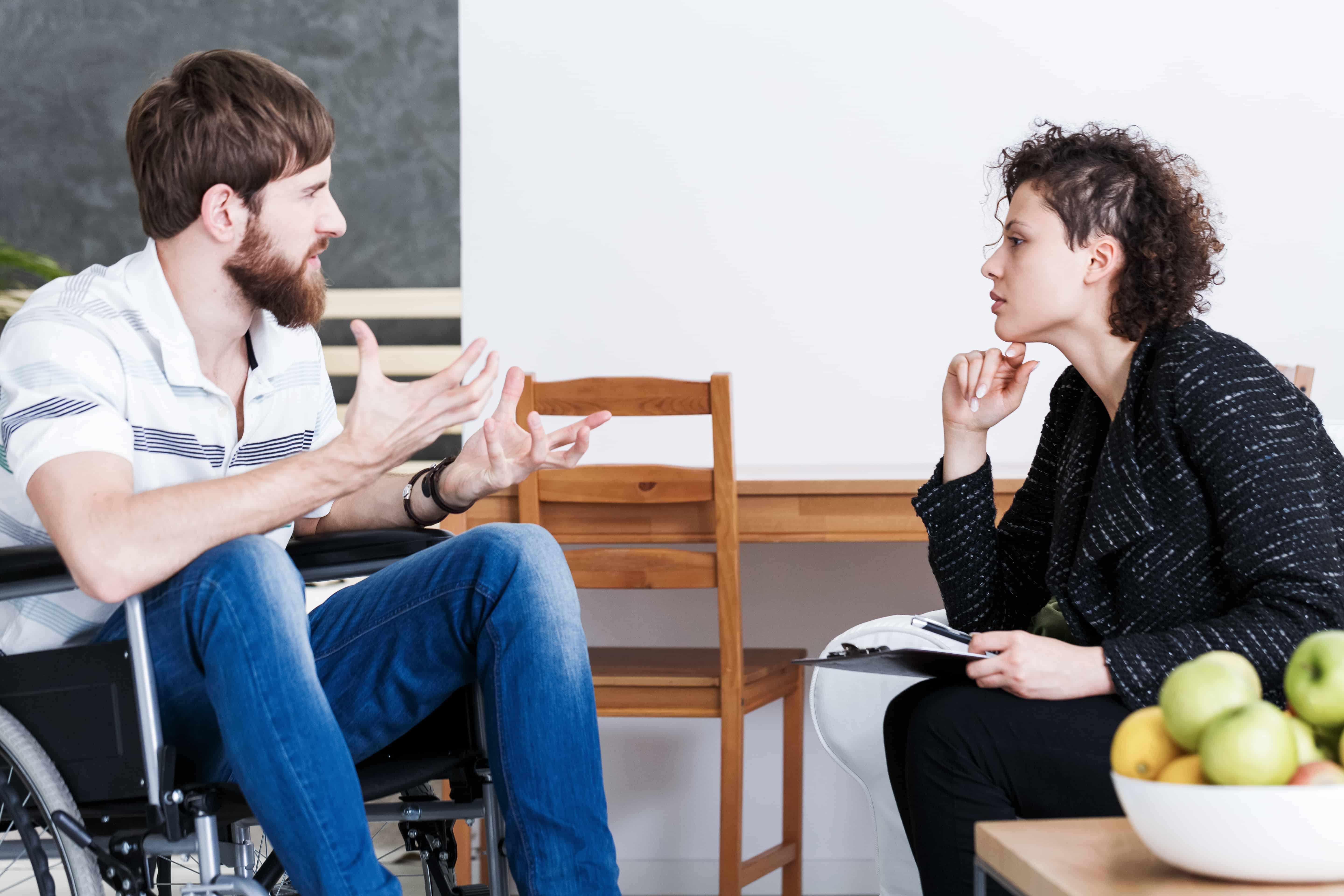 Therapist discussing with handicapped patient