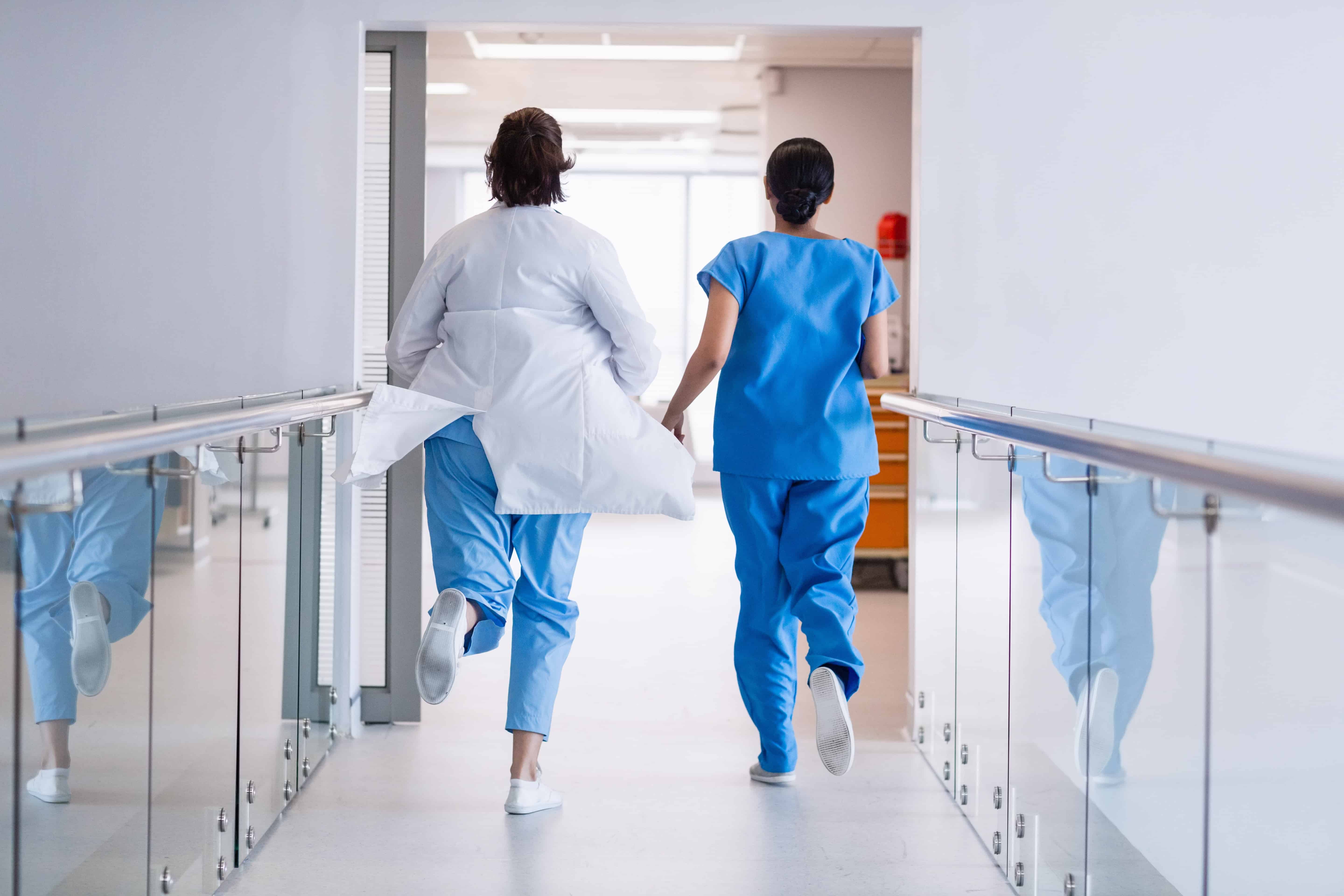 Nurse and doctor running in hospital corridor