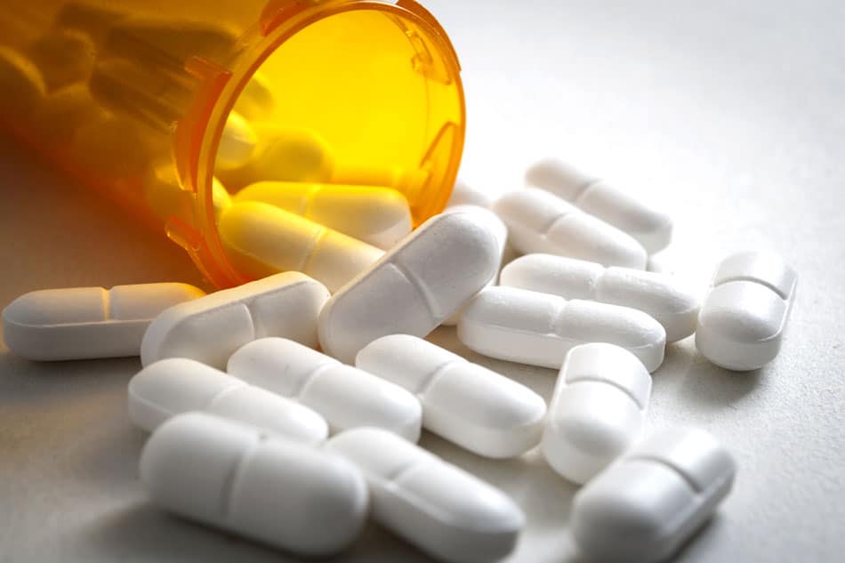 Pill bottle spilling out opioid pills
