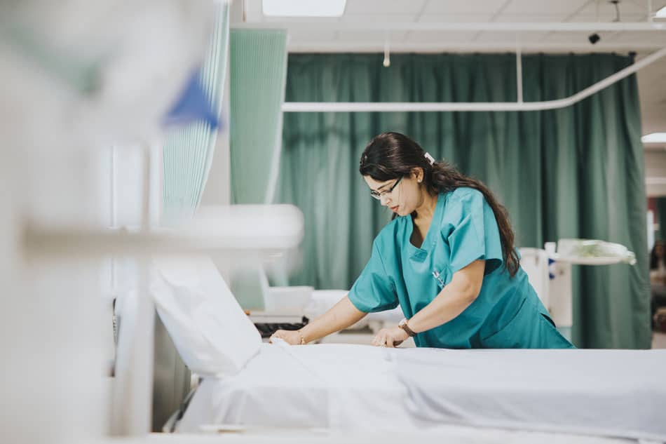 Nurse prepping hospital bed